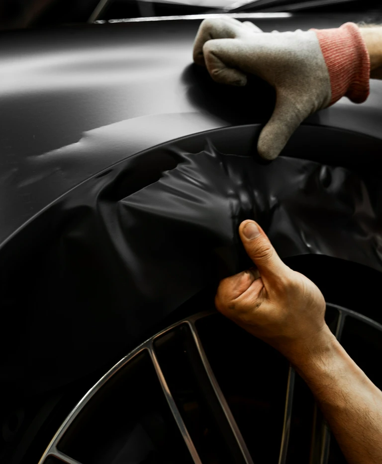 Naklejanie czarnej folii na nadkole samochodu